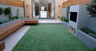 The elegant 'claude' sofa is from pinch. Modern Garden Designer London Artificial Grass Hardwood Seat Fireplace Hardwood Slatted Cedar Screen Trellis Belgravia Hyde Park Westminster London Garden Design