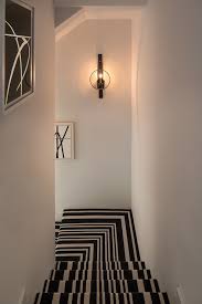 One thing you'll likely notice about this collection is that the majority of staircase sconces are a long, oval, or rectangular shape. Striped Stair Runner Transitional Entrance Foyer Michael Dawkins Home