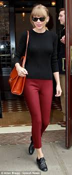 Don't let those bouncy blond curls or the trendy denim fool you: Taylor Swift Color Coordinates Tight Red Trousers With Splashy Orange Handbag After Stepping Out In Frumpy Outfit Daily Mail Online