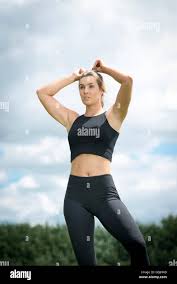 Fit Blonde Woman Wearing Black Sports Bra And Leggings Resting After Exercise Stock Photo Alamy