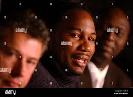 Lennox Lewis, with manager, Adrian Ogun, in background , and promoter,  Jerome Anderson, foreground, at a press conference in Leicester Square,  central London to gives his reaction to the news that his