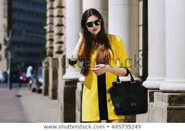 If you are in the business of adding to your already awesome closet, be sure you give your dress collection a good look before you declare yourself done. Fashion Young Woman In Sunglasses Holding Black Handbag Walking Stock Photos And Images Avopix Com
