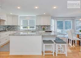 Here, a soft blue paint color makes this island stand out amid white cabinetry, subway tile, and marble countertops. Foxborough White Kitchen With Unique Island Norfolk Kitchen Bath