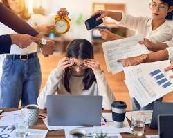 Image of overworked employee feeling stressed at desk multiple hands pointing tasks photo reference