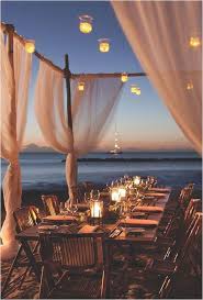 A beach wedding centerpiece with a wood slice, driftwood, candle lanterns and coral blooms plus rope. 35 Gorgeous Beach Themed Wedding Ideas Elegantweddinginvites Com Blog