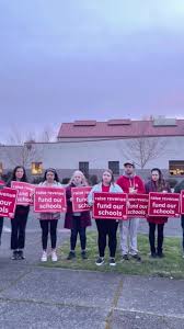 Addison Cochran, 12, and Jim Fenske search for trash along the shores of  the Columbia River during a Martin Luther King Jr. Day beach cleanup event 