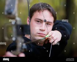 Young man aiming bow arrow hi-res stock photography and images