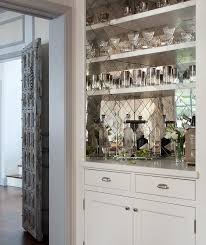 We guarantee you will love our friendly, professional, and personal customer service. Stunning Bar Boasts White Bar Shelves Mounted On Antiqued Mirrored Herringbone Backsplash Tiles Over White Cabinets Bar Backsplash Home Bar Designs Kitchen Bar