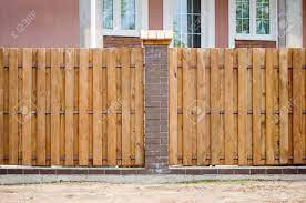 Most often, the concrete is smooth and gray, with geometric gaps and lines for interest. Fragment Of A Wooden Brown Modern Fence With Brick Columns Close Up Stock Photo Picture And Royalty Free Image Image 103120048