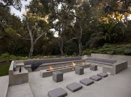 Minimalist Stone Outdoor Conversation Pit With Benches And A Long Narrow Fireplace Glass Pavilion Modern Outdoor Lounge Patio Design