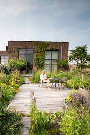 Gardening tools and spring flowers on the terrace. The New Luxury Rooftop Gardens Roof Terrace Design Rooftop Garden Backyard Landscaping