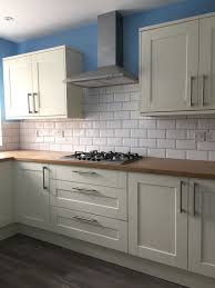 Artwork and kitchen accessories repeat the room's color scheme. Howdens Fairford Antique White With Oak Affect Worktop Antique White Kitchen Howdens Kitchens Kitchen Design