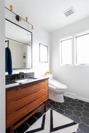 Patterned floor in white and black bathroom interior with towels, toilet and bathtub. Modern Black And White Bathroom Bright Green Door