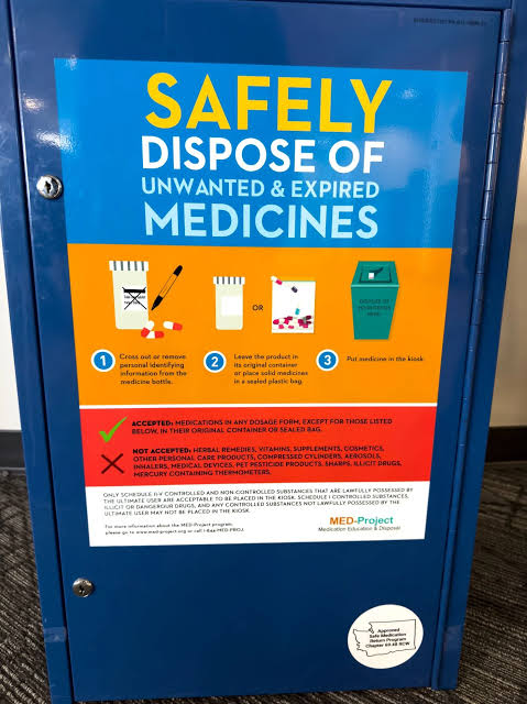A person checking the printed expiration date on a medicine label