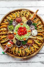 A variety of cheeses and deli meat slices are layered with vegetables, peppers and spices to create a mighty party platter that's filled with exciting flavors and easy on the eyes. Fingerfoodrezepteschnell Partyrezepteschnelle Einfachegerichte Snacksfurparty Grillenrezepte Party Food Platters Easy Taco Recipes Party Food Appetizers