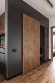 The Large Wooden Door Matches The Floor And Ensures Cohesiveness Throughout The Apartment Sliding Door Design House Design House Interior