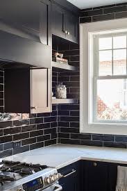 Stacked Dark Blue Floating Shelves Are Mounted Against Glazed Black Horizontal Backsplash Tiles Under Dark Above Cabinets Blue Kitchens Kitchen Cabinet Design