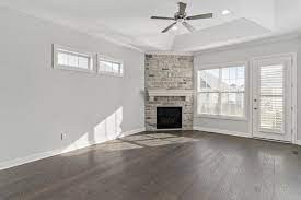 Natural Stone Corner Fireplace With A Painted White Wood Mantle Light Grey Walls Dark Wood Floors Grey Walls White Trim Light Grey Walls Gray Painted Walls