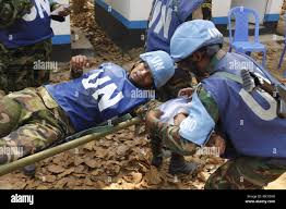 U.N. Peacekeepers from Bangladesh and Sri Lanka simulate giving medical aid  to a member of their platoon after a simulated firefight with rebel  role-players as part of a field training exercise on