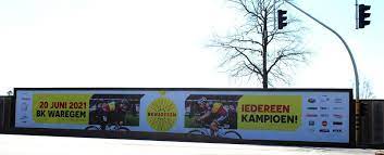 De wegritten starten in antwerpen. Campagnebeeld Van Bk Wielrennen 2021 Waregem Prijkt Op Banner Langs Expresweg Kw Be