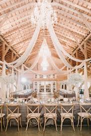 Barn Wedding Reception Decor Idea Barn Venue With Chandeliers Draped Fabric Gray Barn Wedding Reception Rustic Wedding Decor Wedding Reception Decorations