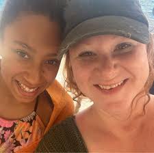 Cat watching fish from under aquarium stand