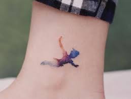 Peter Pan Farbiges Tattoo Am Knochel Kleine Tattoo Motive Fur Frauen Foot Tattoos For Women Foot Tattoos Sleeve Tattoos For Women