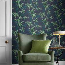 A green floral material wraps the walls like the woods outside and continues onto the bed, a bench, and the curtains. Oriental Bamboo Midnight Wallpaper Blue Wallpaper Graham Brown