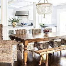 A beautifully distressed trestle table is surrounded by wicker chairs in a grey wash. White Wicker Dining Chairs Design Ideas