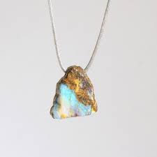 Boulder opal is a rock that contains thin seams and patches of opal surrounded by or attached to its natural host rock. Anhanger Boulder Opal Cum Corde Angelika Brinkmann