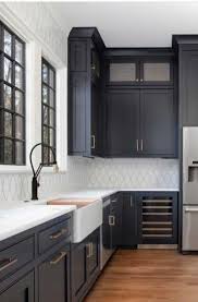 Black kitchen cabinets are tempered here with the light wood island and countertops. 23 Black Kitchen Cabinet Ideas Sebring Design Build