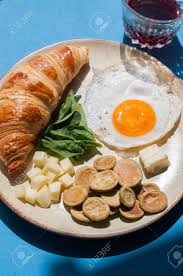 Serve it with a scoop of roasted potatoes and fresh fruit. Healthy Breakfast Fried Eggs With Spinach Pancake Cereals Cheese And Croissant In A Plate Blue Background And Overhead View Stock Photo Picture And Royalty Free Image Image 148352599