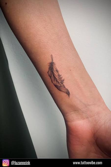 A fine-line feather tattoo
