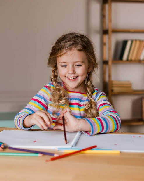 Retrato de niña pintando con lápices de colores | Foto gratuita