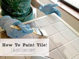 White wall cabinets and butcher block countertops keep things balanced. Livelovediy How To Paint Tile Countertops How To Paint Tile Paint Tile Painting Tile