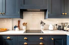 Dark blue kitchen cabinets with brass hardware. Old Windsor Kitchen Herringbone Kitchens