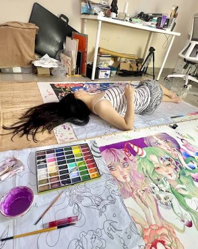 Seorang seniman asal Indonesia, Liffi Wongso, viral di platform X setelah  membagikan cara uniknya saat membuat karya. Dalam unggahannya, ia terlihat  menggambar ilustrasi berukuran besar sambil tiduran di atas kertas gambar.  Postingan
