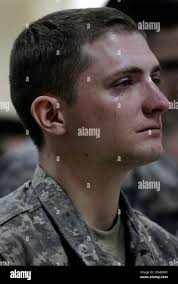 U.S. Army Lt. Kenneth Savage weeps as the names of three fallen comrades  from B Company, First Squadron, Second Stryker Cavalry Regiment are called  out during their memorial service in Baghdad, Iraq