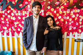 Image of Portrait Of Young Happy Indian Couple In Love Standing Against  Floral Background, Boyfriend Girlfriend Relationship, New Year Or  Valentines Day.-SM413728-Picxy