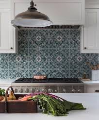 A seafoam green backsplash proves a perfect backdrop for the natural wood flooring, ceiling beams, and island in this cozy kitchen. Tan And Green Mosaic Tile Backsplash Design Ideas