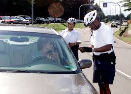 Сержант ВВС США Бойд (справа) проверяет удостоверения личности, в то время  как Монтано наблюдает за самолетом первого класса ВВС США AIRMAN.  Патрульные проводят выборочные проверки, чтобы удостовериться, что персонал  базы соблюдает закон