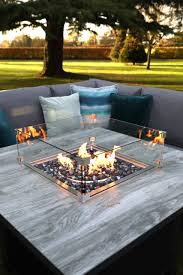 Round brick fire pit surrounded by a row of tiny gravel built in the middle of the grass in the backyard. Buy Melbury Large Corner Suite Online