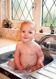 If this is the case, or if your baby isn't quite able to sit up yet, try making the move to the big tub by using a bath seat under your constant supervision. Child Bath In Kitchen Sink Baby Splash And Play In Water Stock Photo Picture And Royalty Free Image Image 5778088