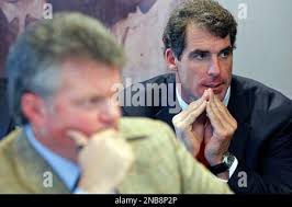 Former pro football player and now Oxford, Miss., resident Todd Wade, rear,  and Attorney General Jim Hood, left, listen as Wade's case before the state  Election Commission is discussed, Friday, Sept. 9, 2011 in Jackson, Miss.  The Election Commission ...