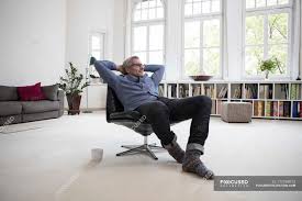 Young happy attractive businessman leaning relaxed sitting on office chair isolated on white. Relaxed Mature Man Sitting In Chair At Home Looking Away Daytime Stock Photo 177769512
