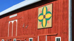 A red barn in northwest iowa with a barn quilt mounted near the top. Marshall County Barn Quilt Trail Visit Marshall County