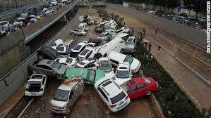 People wade through floodwaters along a street following heavy rains in zhengzhou, in china's central henan province, july 20, 2021. Nblw2uck9ehfim