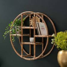 Étagère murale en métal de couleur cuivrée qui se compose de deux parois latérales et de trois planches en métal blanches. Etagere Murale Ronde En Rotin Style Vintage Casatera Decoclico
