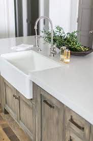 A Polished Nickel Pull Down Faucet Is Paired With A Farmhouse Sink And Mounted To A White Q Kitchen Sink Design Farmhouse Sink Kitchen Trendy Farmhouse Kitchen