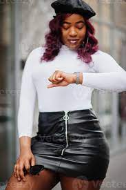 Big mama plus size african american model in black beret and leather skirt  posed outdoor looking time at hand watches. 10497500 Stock Photo at Vecteezy